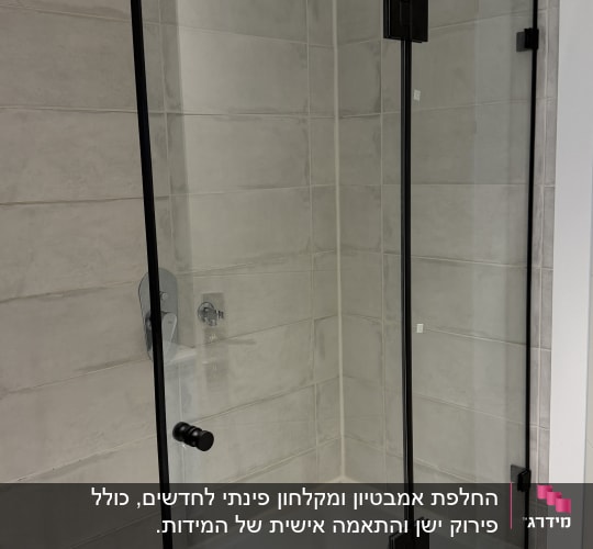 מקלחון זכוכית עם מסגרת שחורה בחדר אמבטיה